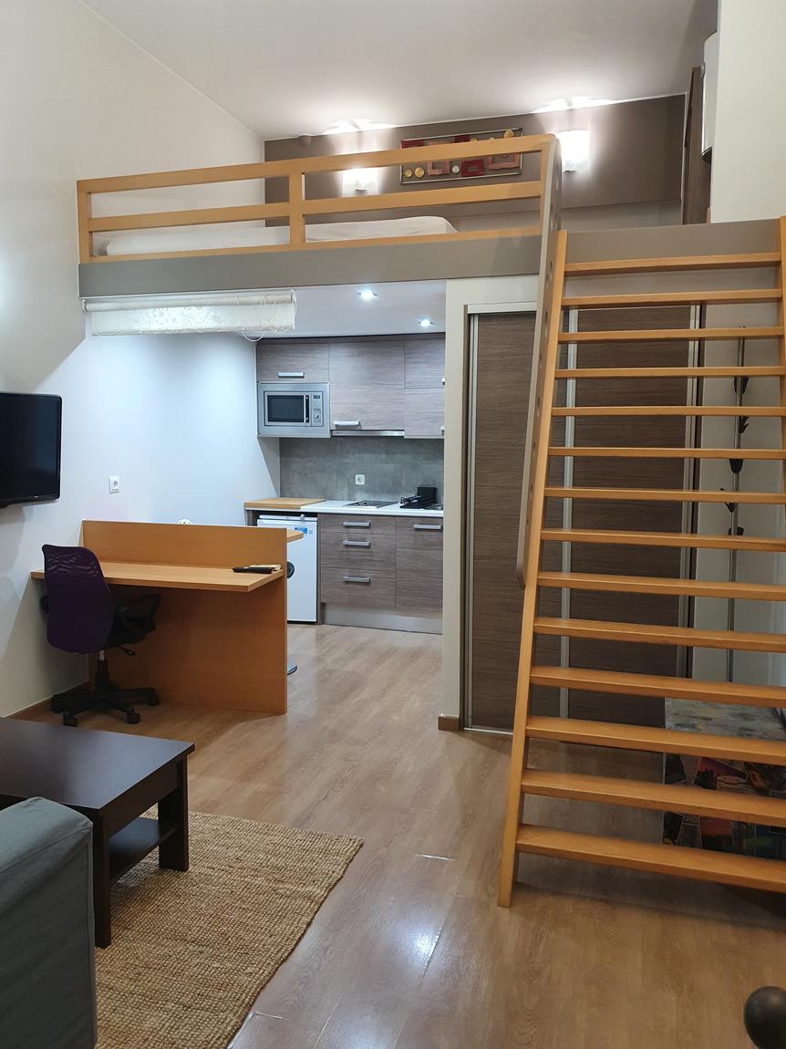 Estudio con altillo y escalera de madera