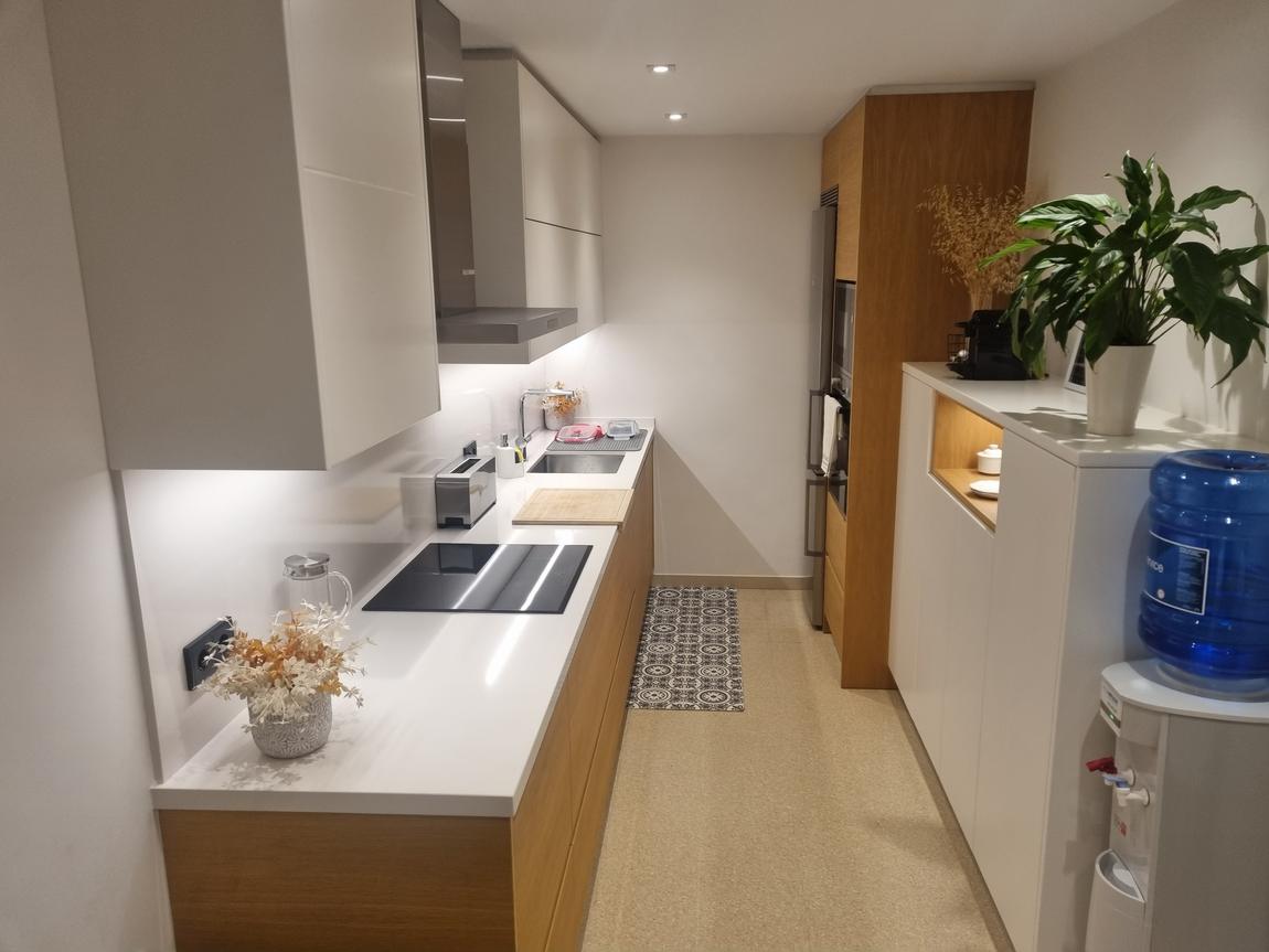 Cocina de roble y blanco con mueble auxiliar